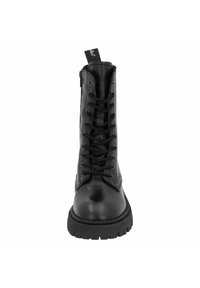 Bota de cuero negro hasta el tobillo con caña alta, puntera redonda, frente con cordones y acentos texturizados en los lados. Suela de goma gruesa que proporciona tracción.