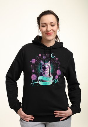 Black hoodie featuring a colorful graphic of a cat surrounded by planets and stars, with the text "COSMIC VIBES" in a ribbon-style banner.
