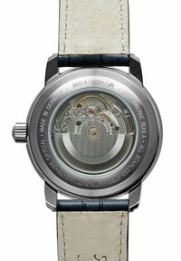 RVS uurwerk achterzijde met ingewikkelde details van de beweging, voorzien van saffierglas. Beige leren strap met blauwe accenten; gegraveerde tekst.