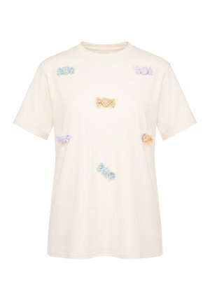 Kortærmet cremefarvet t-shirt med spredte pastelfarvede båndsløjfer i blå, gul og lilla på forsiden.