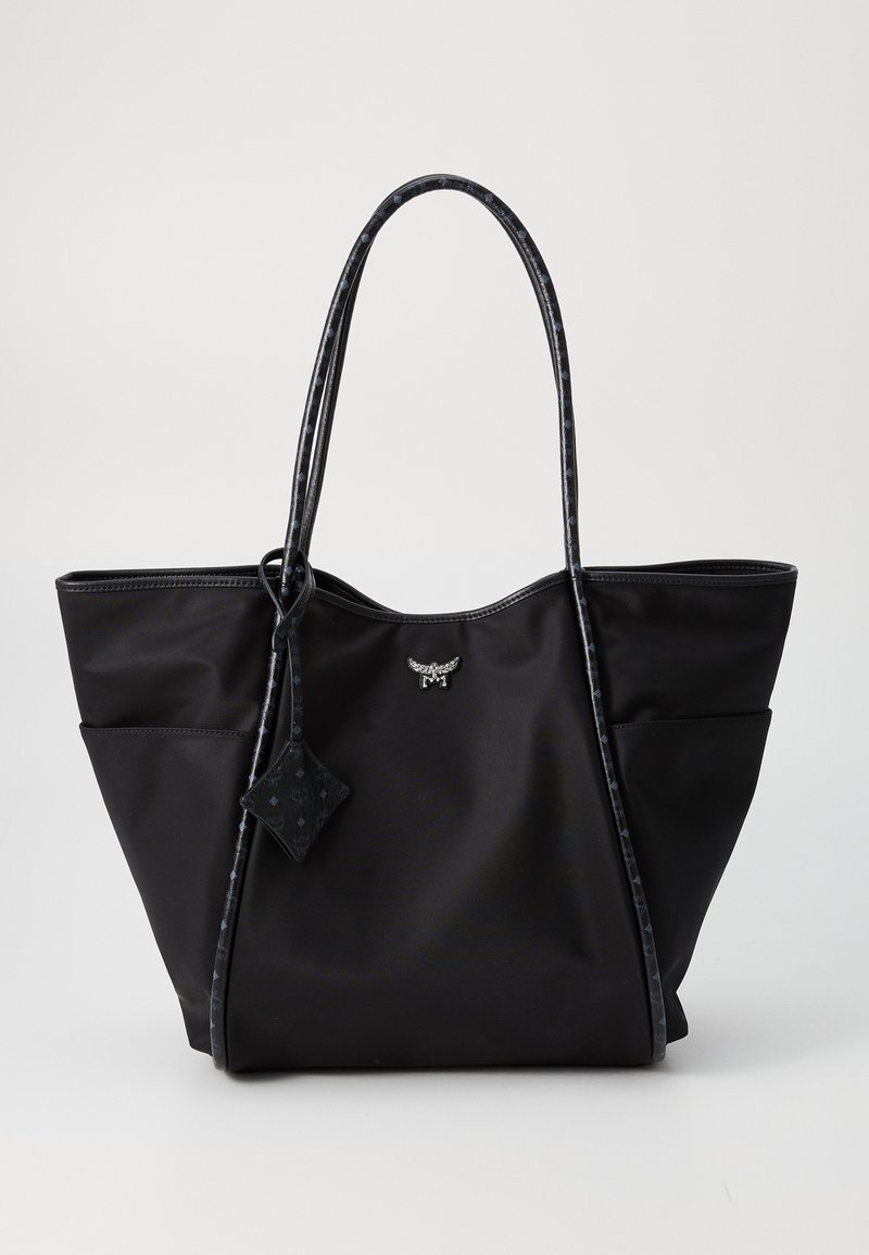 Czarna torba na ramię z długimi wzorzystymi uchwytami, bocznymi kieszeniami i małym metalowym logo na środku przodu.