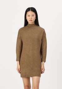 Brun strikket kjole med høy krage, 3/4-lange ermer, ribbede kanter og skulderknapper. Myk tekstur og tettsittende design.
