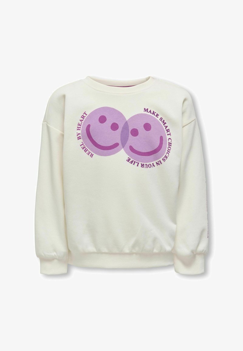 Sweat-shirt crème avec deux visages souriants violets superposés et texte incurvé disant « Rebelle dans l'âme » et « Faites des choix intelligents dans votre vie. »