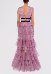 Abito in tulle viola a strati con scollatura a V profonda, caratterizzato da una fascia nera contrastante in vita. Il design include numerosi volants che scendono.