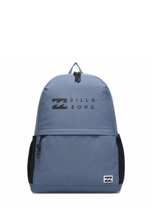 Sac à dos Billabong bleu avec fermetures éclair noires, poches latérales en mesh et logo imprimé sur la poche avant et la partie supérieure.