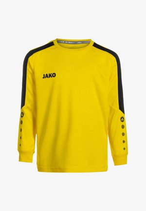 Gele sportshirt met lange mouwen en zwarte schouderpanelen, met een klein logo en decoratieve stippen langs de mouwuiteinden.