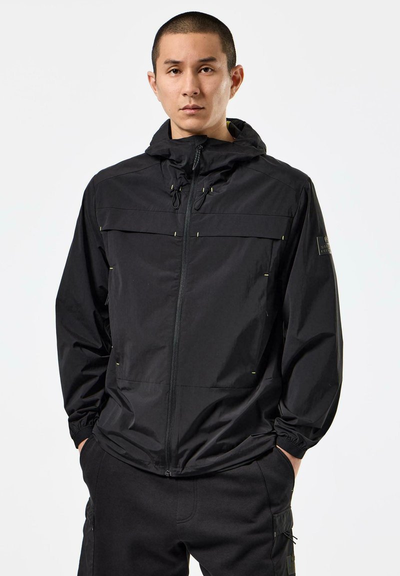 Black lightweight jacket with a zip front, adjustable hood, and two front pockets. Features elastic cuffs and subtle yellow accents.