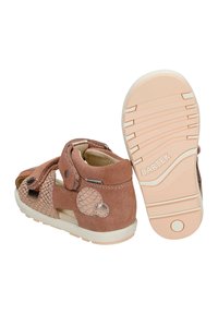 Sandales marron pour tout-petit avec des sangles réglables et une semelle texturée, l'une d'elles montrant le nom de la marque "Bartek" sous la semelle.