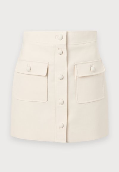 Jupe en denim de couleur crème avec une fermeture à boutons sur le devant, deux poches à rabat et une silhouette ajustée. Texture lisse, ourlet droit.