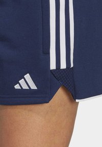 Marineblauwe sportshorts met witte zijstrepen, voorzien van een textuur-mesh paneel en een geborduurd wit logo op de zoom.