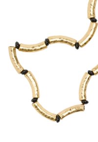 Naszyjnik z koralików w odcieniu złota, zawierający młotkowane, cylindryczne ogniwa przeplatane gładkimi, czarnymi akcentami.