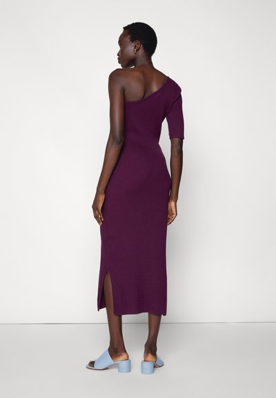 Vestido roxo com uma alça, textura estriada, manga curta e fenda lateral, combinado com mules de salto azuis. Textura suave e design ajustado.
