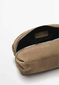 Pochette in suede marrone con chiusura a zip, caratterizzata da una consistenza morbida e un interno nero. Un'etichetta con "Massimo Dutti" è visibile all'interno.