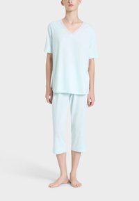 Set di pigiama in cotone azzurro chiaro, composto da una maglietta a maniche corte con scollo a V e pantaloni a 3/4. Il tessuto appare morbido e liscio.