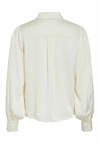 Bluza dugih rukava u krem boji s napuhanim rukavima, dugmadi na manžetama i detaljem s nabranim leđima, prikazana sa stražnje strane.