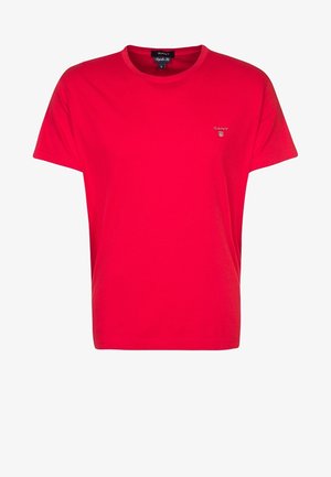 T-shirt en coton rouge à manches courtes, col rond et petit logo brodé sur la poitrine. Texture douce, coupe décontractée.