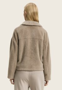 Beige faux fur jas met een relaxte pasvorm, brede kraag en afhangende schouders, met een textuur op het oppervlak en een rechte achterzoom.