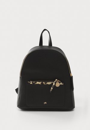 Mochila negra con un diseño estructurado, fabricada en material suave, que presenta un bolsillo frontal de estampado de leopardo y acentos en dorado.