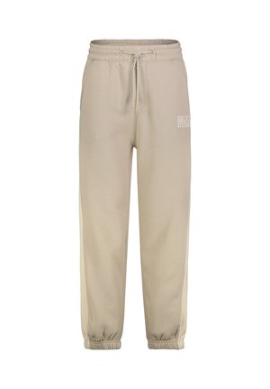 Beige Sweatpants mit elastischem Bund und Kordelzug, Seitentaschen, elastischen Bündchen und weißem "SBLVSTUDIO"-Schriftzug am linken Oberschenkel.