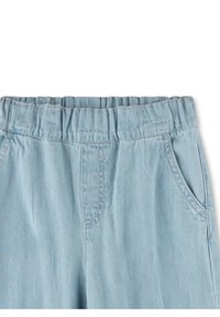 Hellblaue Jeanshose mit elastischem Bund, zwei Seitentaschen und einer weichen Textur mit subtilen Steppdetails.