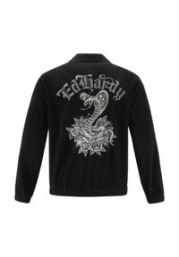 Mustan corduroy-takin, jossa on brodeerattu käärmeasu ja kukkakoristeet selässä. Joustavat hihansuut ja vyötärö varmistavat sopivuuden.