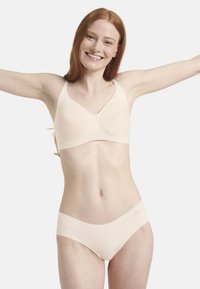 Hellbeige Lingerie-Set mit einem nahtlosen BH mit breiten Trägern und einem passenden Slip. Glattes Material mit einem minimalistischen Design.