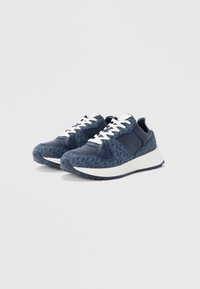 Marineblaue Sportschuhe aus strukturiertem Stoff mit glatten Lederakzenten, weißen Schnürsenkeln und einer dicken weißen Zwischensohle.