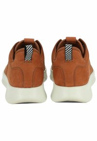 Braune Ledersneaker mit einer weißen Gummisohle, ausgestattet mit einem strukturierten Rücken, einem Stoffziehband und einem gestreiften Akzent am Band.