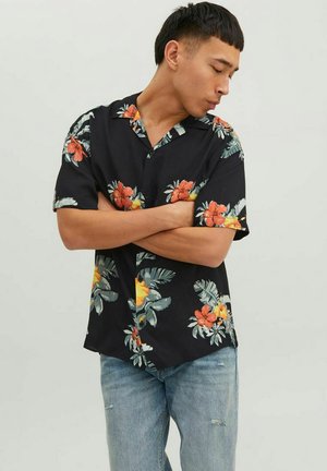 Maglietta nera a maniche corte con motivo di fiori e foglie tropicali in rosso, arancione e verde. Taglio dritto, colletto a bottoni, tessuto leggero.