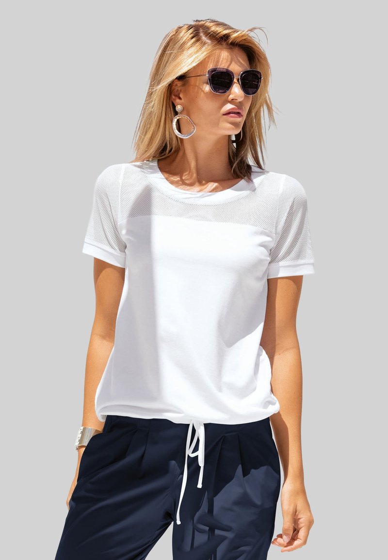 Witte short-sleeve t-shirt met een bovenpaneel van mesh, ronde halslijn en een relaxte pasvorm, gecombineerd met marineblauwe broek en zilveren sieradenaccenten.