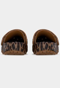 Ζευγάρι καφέ κλοτς με μαύρο λεοπάρ σχέδιο και ρυθμιζόμενα λουριά στο τακούνι, ορατά από πίσω πάνω σε απλό ανοιχτό φόντο.