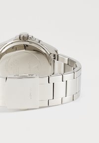 Orologio in acciaio inox con finitura lucida. Presenta una cassa rotonda, un bracciale in metallo e una chiusura con marchio incisa.