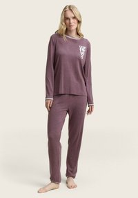 Langzaam met lange mouwen pyjama set in kastanjebruin met wit logo op de borstzak, contrasterende gestreepte halslijn en bijpassende broek met aansluitende boorden.