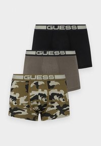 Trys bokserių trumpikės juodos, pilkos ir kamufliažo raštų. Kiekvienoje yra platus elastinis diržas su "GUESS" užrašu šviesiai pilka spalva.