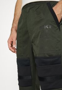 Nike Sportswear CITY MADE PANT - Chinos - sequoia/black