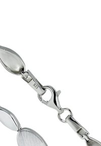 Bracelet en argent avec des maillons ovales lisses et texturés, une fermeture à mousqueton et un poinçon indiquant l'argent sterling 925.