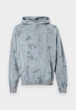 Bluza z kapturem w kolorze jasnoniebieskim z motywem lasu. Posiada kieszeń kangurka oraz ściągacze na rękawach. Miękka w dotyku i o luźnym kroju.