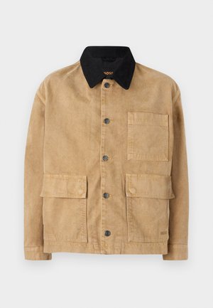 Katoenen jack in lichtbruin met een zwarte kraag, met een sluiting met knopen aan de voorkant, twee grote voorzakken en een enkele borstzak.