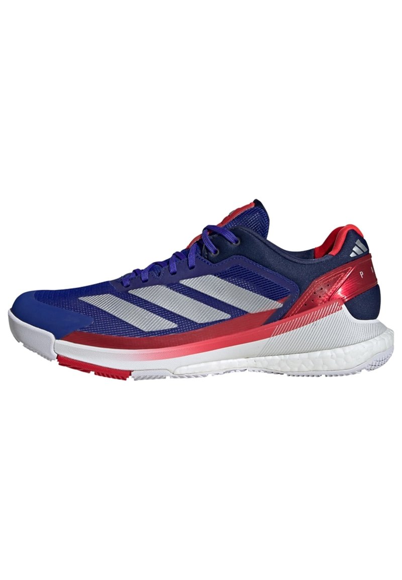 Blue athletic shoe with silver stripes, red accents, textured mesh upper, and a cushioned white sole designed for performance and comfort.