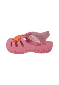 Sandal in plastica rosa con ventilazione a taglio, un'applicazione a forma di stella e una cinghia trasparente scintillante. Decorata con piccoli motivi a stella.