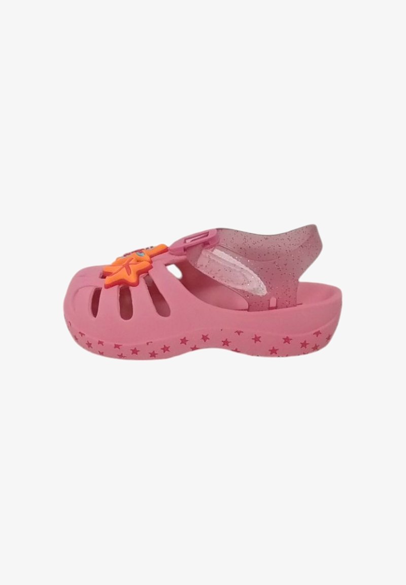 Sandal in plastica rosa con ventilazione a taglio, un'applicazione a forma di stella e una cinghia trasparente scintillante. Decorata con piccoli motivi a stella.