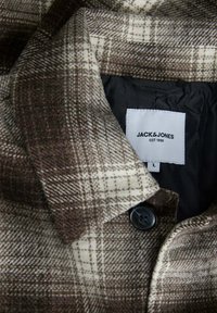 Cappotto di lana a quadrati marrone e crema con un bottone nero, dotato di colletto e etichetta "JACK & JONES" su un'etichetta bianca.