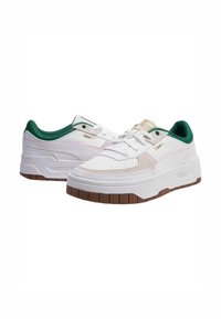 Hvite sneakers med grønne detaljer, med perforert tekstur, lagdelt design, gullfarge hardware og en tykk brun gummisåle.