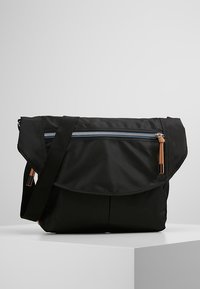 Borsa a tracolla nera realizzata in tessuto resistente, con una pattella pieghevole, tasca con zip, tracolla regolabile e dettagli in hardware beige.