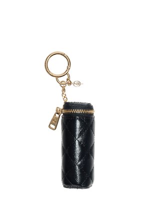 Porte-clés cylindrique en cuir matelassé noir avec fermeture éclair dorée et anneau porte-clés doré fixé par une petite chaîne.