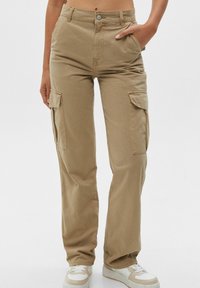Pantalon cargo beige en coton avec une coupe droite. Comprend deux poches latérales et une fermeture à bouton. Tissu texturé.