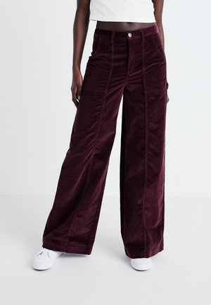 Corduroy wijdbenige broeken in diep bordeauxrood met een gestructureerde afwerking, voorzien van voorzakken en een knoopsluiting aan de taille.