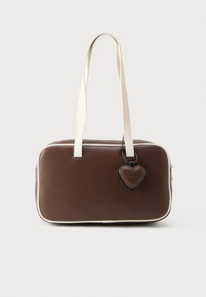 Brown faux leather handbag with white trim, rectangular shape, short handles, and decorative heart-shaped tag attached.