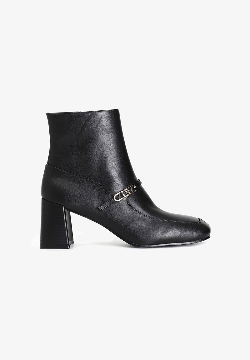 Schwarze Leder-Ankle-Boots mit quadratischer Zehenform, Blockabsatz und einem dekorativen Riemen mit einem goldfarbenen Schnallen-Detail. Glatte Textur.