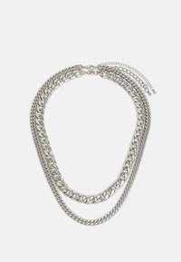 Silver multi-layered chain necklace featuring varying widths of links, a smooth texture, and a clasp with adjustable extender chain.